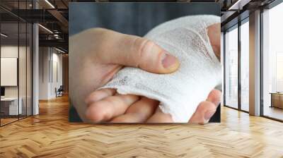 Man shows wounded arm rewound with white bandage Wall mural