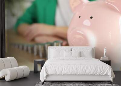 Raising stacks of coins and piggy bank on table Wall mural