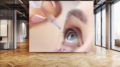 Woman drips eye drops into her eyes Wall mural