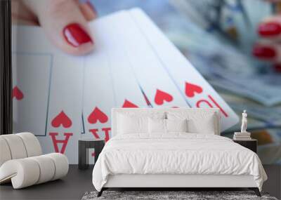 Woman holding dollar bills and playing cards in her hands Wall mural