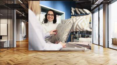 Woman salesman showing decorative pillow in salon Wall mural