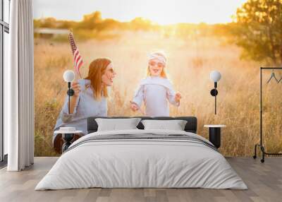 Patriotic mother and daughter with American flag Wall mural