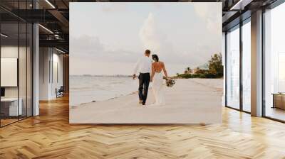 Perfect Sunset Destination Beach Wedding with Beautiful Bride and Groom Walking Down the Coastline Wall mural