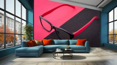 Pair of reading glasses on back and red background Wall mural