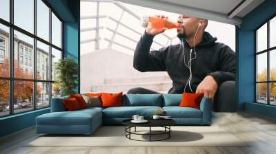 Athletic man drinking something after training. Wall mural