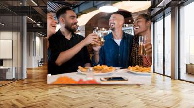 Group of friends enjoying a meal together at a restaurant. Wall mural