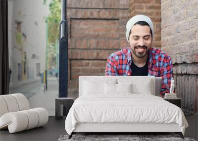 latin man using a tablet. Wall mural