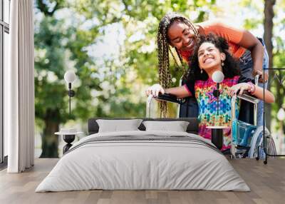 Little girl in a wheelchair at the park with her mother. Wall mural