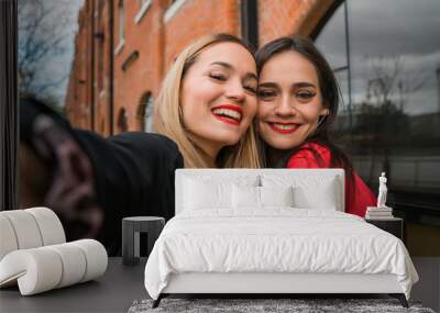 Two young friends taking a selfie outdoors. Wall mural