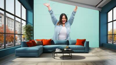 Young plus size woman celebrating victory. Wall mural