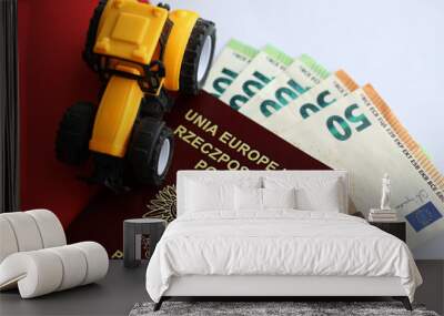 Red polish passport and yellow tractor on euro money and smooth red and white flag of Poland close up Wall mural