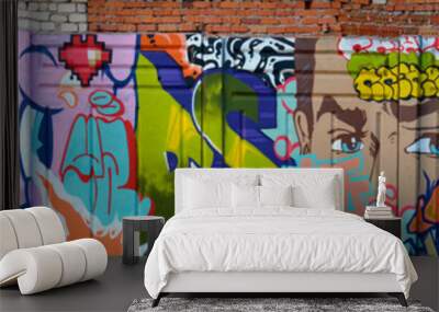 The old wall decorated with paint stains in the style of street art culture. Colorful background of full graffiti painting artwork with bright aerosol outlines on wall. Colored background texture Wall mural