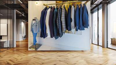 Men's jackets on hangers in the men's store. Row of men's suits hanged on a rack. Men's wear collection. Wall mural