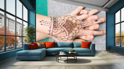 Artist applying henna tattoo on women hands. Mehndi is traditional Indian decorative art. Close-up Wall mural