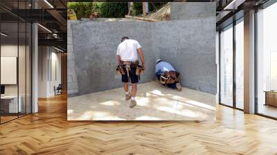 Carpenters marking a layout for new walls on a plywood deck Wall mural