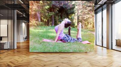 Beautiful woman exercising in the forest in the morning Wall mural