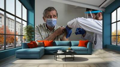 Doctor giving a senior woman a vaccination. Virus protection. COVID-2021. Wall mural