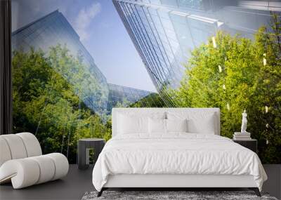 green city - double exposure of lush green forest and modern skyscrapers windows Wall mural