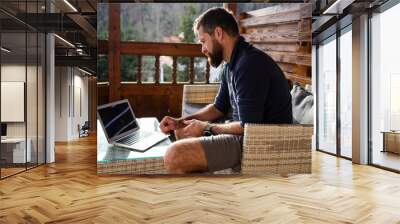 man working on laptop in wooden cottage Wall mural