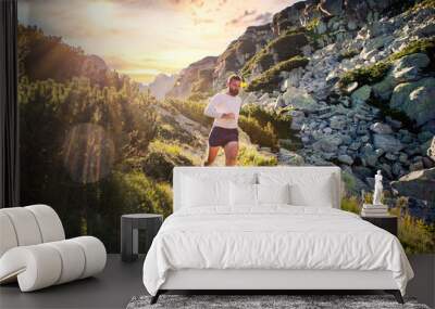 trail runner running in mountain landscape at sunset active lifestyle Wall mural