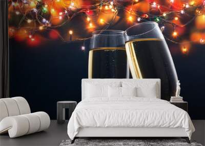 two champagne glasses ready to bring in the New Year - holiday lights and fireworks in the background Wall mural