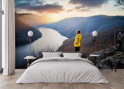 woman on rock enjoying amazing autumn view over lake at sunset Wall mural