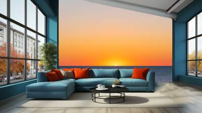 Orange sunrise over the ocean and sandy beach Wall mural