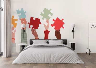 Group of multi-ethnic business people with raised arms holding a piece of jigsaw. Colleagues of diverse races and culture. Cooperate and collaborate. Concept of teamwork and success Wall mural