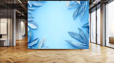 Blue leaves and foliage on blue background with copy space. Wall mural