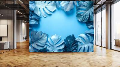 Blue tropical leaves and foliage on blue background with copy space. Wall mural