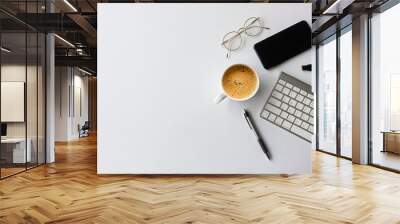 business concept. top view of office desk workspace with smartphone, pen, keyboard, glasses and hot coffee cup on white table background. over light Wall mural