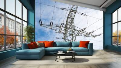 Electricity pole with cables high in the blue cloudy sky Wall mural