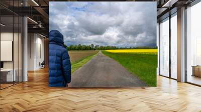 Man on the country road in stormy weather Wall mural