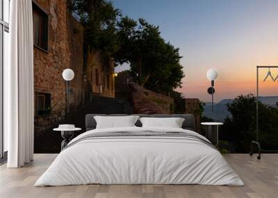 Evening view of an old street in the historic small town of Fosdinovo in Tuscany, Italy with a beautiful colored twilight sky over the mountains at the Ligurian coast Wall mural