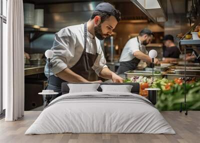 Handsome chef preparing vegetable salad in commercial kitchen of restaurant or hotel Wall mural