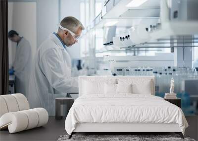 Scientist working in a laboratory. Young male researcher carrying out scientific research in a lab. Wall mural