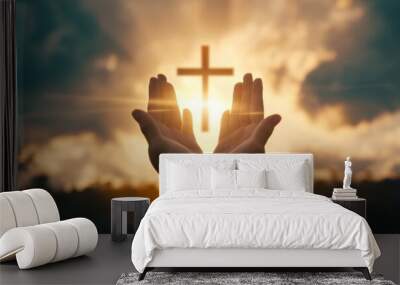 Silhouette of hands presenting Christian cross against sunset Wall mural