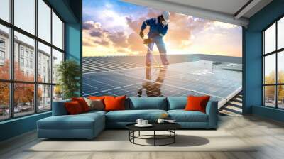 Man using a mop and water to clean the solar panels that are dirty with dust and birds' droppings to improve the efficiency of solar energy storage. Wall mural