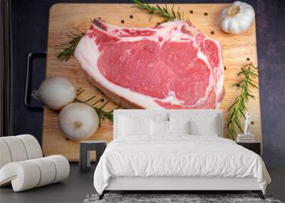 Raw fresh Rib eye steak beef with herbs on wooden background, Close-up view of marble Rib eye steak beef for steak on wooden plate. Wall mural