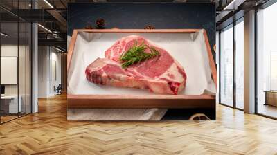 Raw T-bone steak beef with rosemary on wooden plate, T-bone steak beef (Sliced) on black wooden background. Wall mural