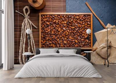 Roasted Cocoa beans on brown wooden plate, Aromatic Cocoa beans in wooden plate on wooden table. Wall mural