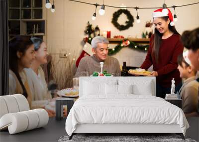 Asian multi generational family gathers around a festive dinner table during July or December Christmas, with food, wreath decorations and a joyful atmosphere while sharing cozy moment Wall mural