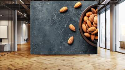 Almonds in a dark wooden bowl on a slate table for healthy diet concept with available copy space image. Wall mural