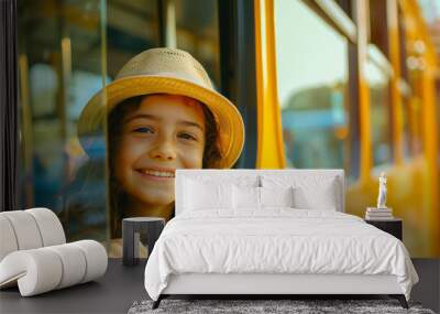 A young girl is smiling and looking out the window of a yellow school bus Wall mural