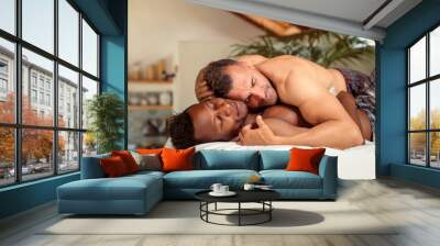 Lovely gay couple cuddling in bed in the morning Wall mural