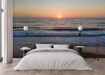 Hazy sunrise seascape with low swell Wall mural