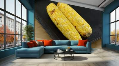 Two ears of blackened roasted corn on baking sheet Wall mural