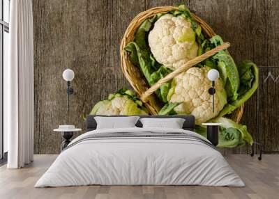 Fresh raw organic cauliflower with leaves on rustic background, uncooked vegetable Wall mural