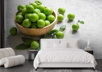 Fresh ripe organic green plums or greengage in bowl on white rustic background, heap of summer fruits concept Wall mural