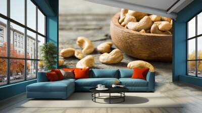 roasted salted raw cashew nuts in wooden bowl on rustic table, healthy vegetarian snack, Anacardium occidentale Wall mural